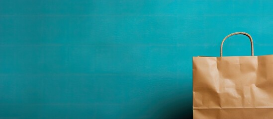 Leinwandbilder - A copy space image showing a brown paper bag against a vibrant turquoise backdrop