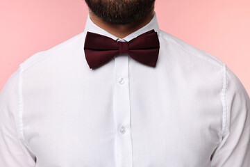 Wall Mural - Man in shirt and bow tie on pink background, closeup