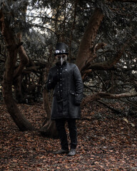 Wall Mural - Man wearing a mask and a black outfit in a forest