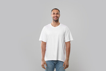 Wall Mural - Man wearing white t-shirt on gray background
