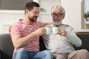 Canvas Print - Happy son and his dad with cups at home