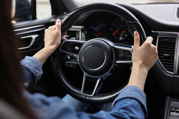 Wall Mural - Woman holding steering wheel while driving her car, closeup