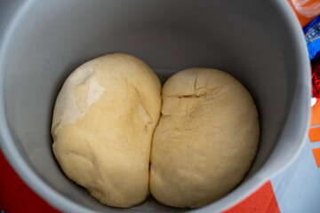 two balls of dough in a bowl on a table with a bag