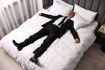 Wall Mural - Businessman in office clothes sleeping on bed indoors