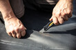© M.Dörr & M.Frommherz - a craftsman cuts a rubber sheet apart with a cutter knife