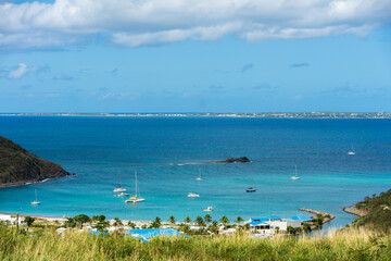 Wall Mural - a beach filled with lots of water next to a lush green hillside