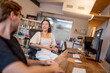 © Austockphoto - Asian woman and caucasian man sitting at a desk discussing ideas in a creative studio space