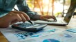 © HDP-STUDIO - Professional at work using a calculator, with a notebook and laptop in the background, highlighting financial planning