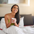© peopleimages.com - Indian woman, home and smile in bed with coffee for wake up in morning and memories. Female person, bedroom and relaxing or thinking with ideas or thoughts and for comfort, wellness or wellbeing