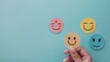 © Milosc - Happy smile face emoticon icons against pastel blue background. Enjoying life concept. Creative concept.