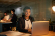 © peopleimages.com - Laptop, night and business woman with smile at desk for project deadline, review or update records. Late, happiness and employee with paperwork for overtime, information or data entry clerk in office