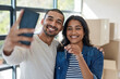 © peopleimages.com - Selfie, house key and couple moving to new home together with cardboard boxes for real estate. Happy, love and young man and woman with photography picture for apartment or property ownership.