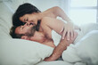 © peopleimages.com - Love, morning and couple in bed with kiss, romance and happy bonding in apartment. Relationship, man and woman relax in bedroom with intimate embrace, passion and wake up with care on weekend in home