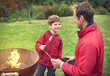 © peopleimages.com - Father, outdoors and son with marshmallow for roasting on flame with bonding for happiness. Child development, smile and camping with scenic campsite in winter morning on weekend away to Germany.