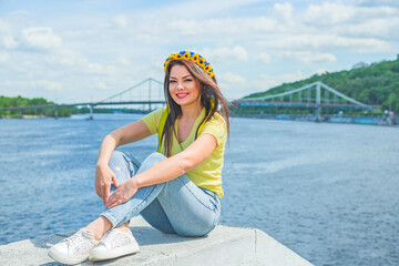 Woman in casual style at city scene, flower wreath in hair. Concept of beauty European girl, romantic style