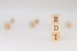 © PHalexaviles - EDI acronym. Concept of Electronic data interchange written on wooden cubes isolated on white background.