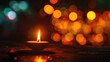 © buraratn - close-up of a single lit candle, with the soft bokeh of temple lights in the background on Magha Bucha Day
