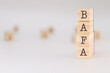 © PHalexaviles - Bafa acronym. Concept of 'brevet d'aptitude aux fonctions d'animateur' written on wooden cubes isolated on white background.