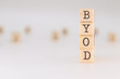 © PHalexaviles - BYOD acronym. Concept of Bring Your Own Device written on wooden cubes isolated on white background.