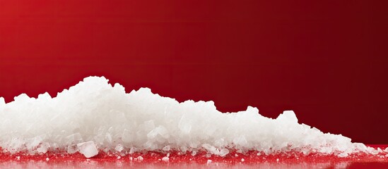 Poster - Pile of white sugar crystals on red background. copy space available