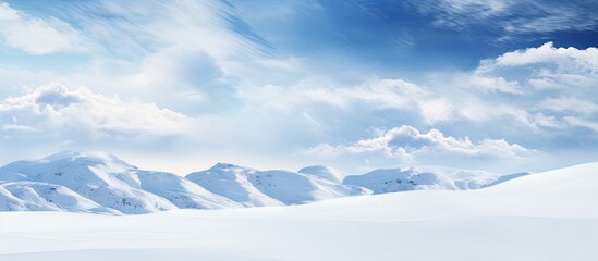 Poster - The dramatic winter landscape is enhanced by the puffy clouds against the blue and overcast sky. copy space available