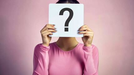 Wall Mural - A woman holding up an empty white card with the question mark symbol on it in front of her face