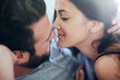 © peopleimages.com - Love, affection and couple in bed with intimate romance, smile and morning bonding in apartment. Relationship, man and woman in bedroom with embrace, passion and relax with care on weekend in home