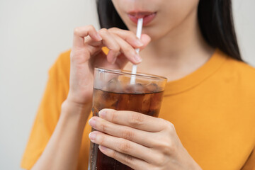 Smile happy thirsty asian young woman drinking or sip, holding glass of ice sparkling soda, cola water with straw, refreshness people, isolated on background. Temptation of food and beverage concept.