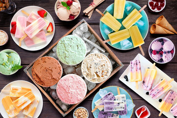 Poster - Cool summer food table scene. Assorted refreshing ice cream, popsicle and frozen treats. Overhead view on a dark wood background.