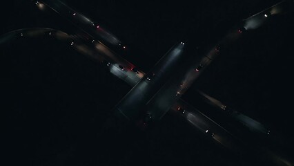 Top View shows a nighttime overpass with car traffic traveling in complete darkness with their headlights illuminating path at an interchange in Dartmouth, Canada. Development of transport 
