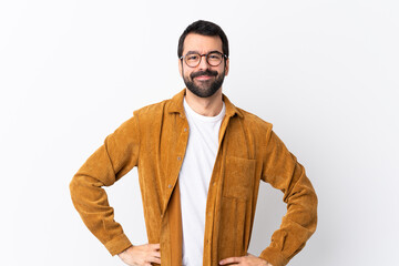 Wall Mural - Caucasian handsome man with beard wearing a corduroy jacket over isolated white background posing with arms at hip and smiling