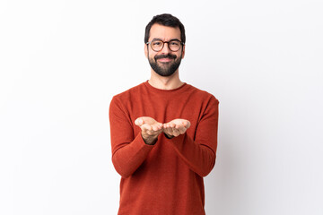 Wall Mural - Caucasian handsome man with beard over isolated white background holding copyspace imaginary on the palm to insert an ad