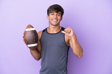 Wall Mural - Young man playing rugby isolated on purple background proud and self-satisfied