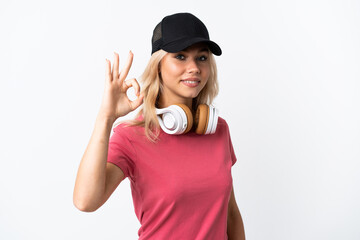 Wall Mural - Young Russian woman listening music isolated on white background showing ok sign with fingers