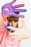 Fototapeta Zachód słońca - Happy woman hiding the face with her painted hands. Creative, art, childhood, drawing concept