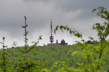 Communication transmitter tower and chapel on the top of Radhost mountain near Roznov pod Radhostem. Cloudy weather in springtime.