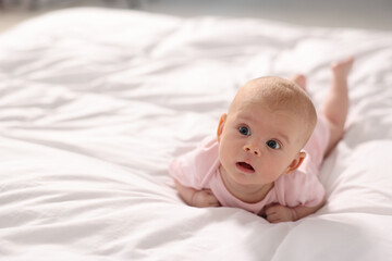 Wall Mural - Cute little baby lying on white sheets, space for text