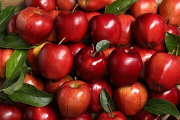 Poster - Fresh ripe red apples with leaves as background, top view