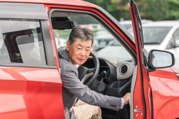 Sticker - 駐車場で自動車のドアを開けてバックする高齢者ドライバーの男性
