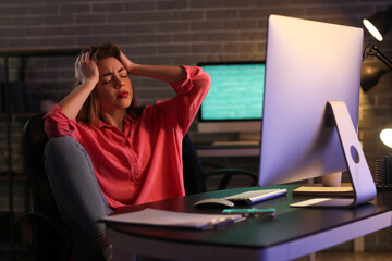 Poster - Stressed female programmer working in office at night