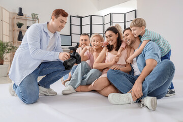 Canvas Print - Big family looking at taken pictures in studio