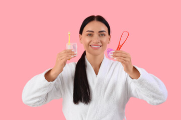 Sticker - Beautiful young happy woman in bathrobe with supplies for oral hygiene on pink background