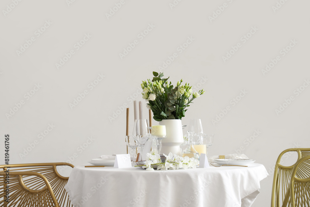 Beautiful table setting with white flowers and candles for wedding celebration in room