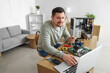 © Pixel-Shot - Male technician with laptop repairing computer at table in service center