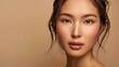 © peerawat - A stunning young Asian woman with pristine skin stands against a beige background. Her flawless complexion emphasizes the benefits of facial care, treatments, and cosmetology