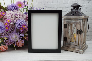 Wall Mural - Empty Photo frame mock up with flower bouquet and home decorations on wooden background