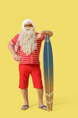 Sticker - Santa Claus with beach bag and surfboard on yellow background. Christmas in July