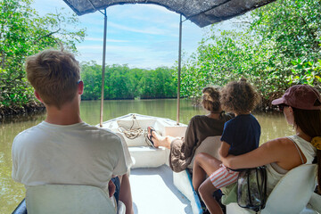 view from behind of a family on a wildlife estuary boat tour in costa rica. exploring the tamarindo 