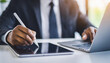 © Your Hand Please - Businessman's hand in black suit using a stylus pen to sign an e-document on a digital device, highlighting modern technology in business, efficiency, and the shift towards paperless transactions
