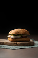 Wall Mural - Roast beef and mozzarella sandwich with ciabatta bun on olive board